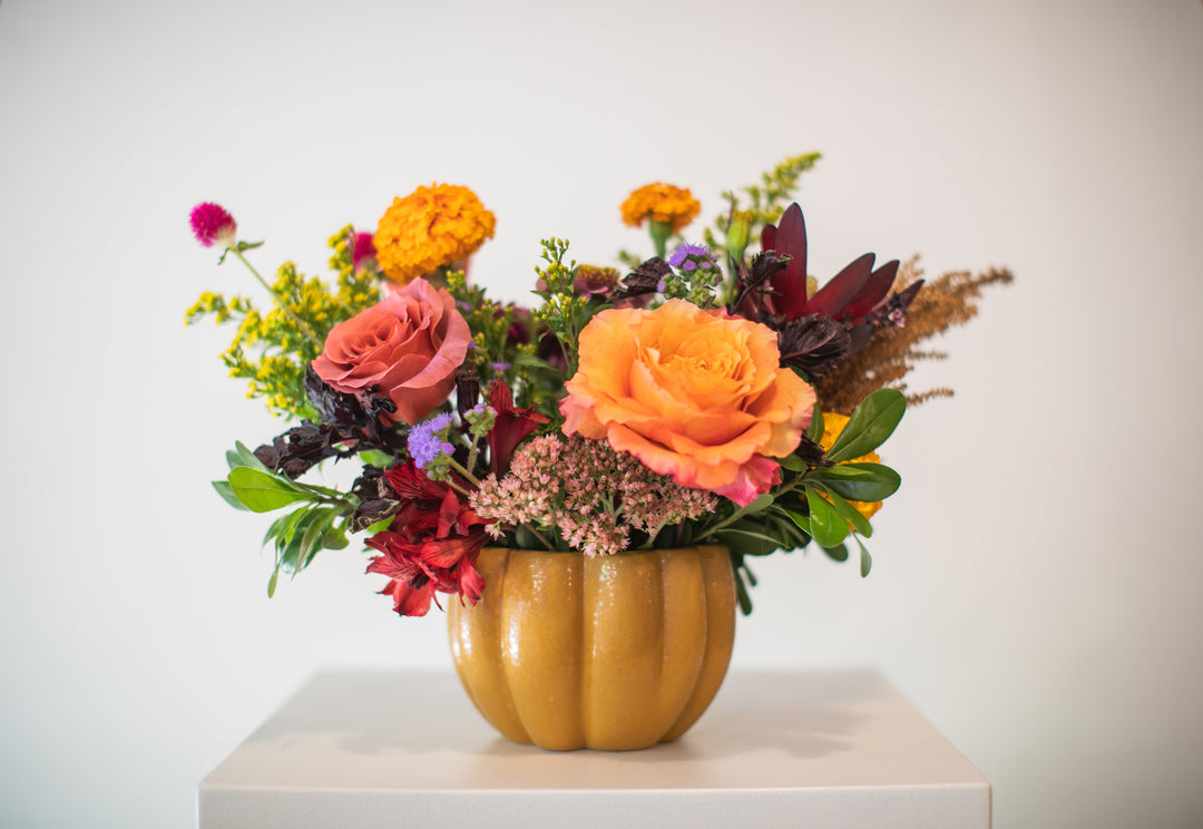Colorful floral centerpiece arrangement in a pumpkin-shaped vase Kansas City delivery Thanksgiving Fall flowers