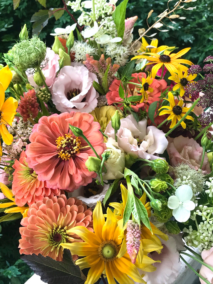 Bouquet of colorful flowers including zinnias, sunflowers, and other varieties.